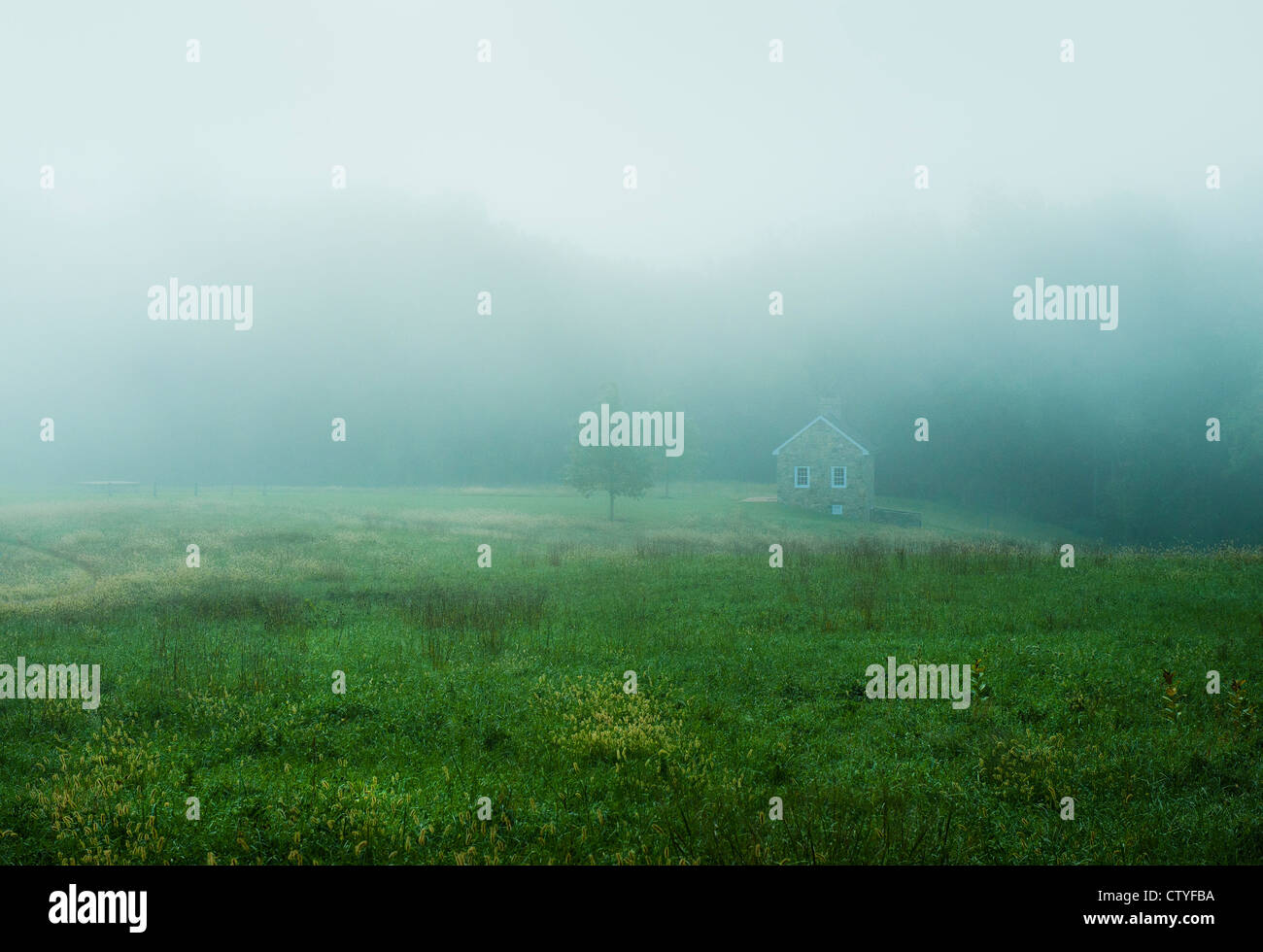 Malerisches Landhaus aus Stein an einem nebligen Morgen. Stockfoto