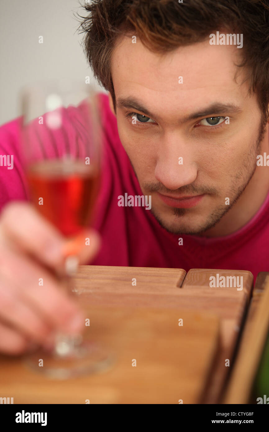 Entschlossenen Mann, Blick auf ein Glas Wein Stockfoto