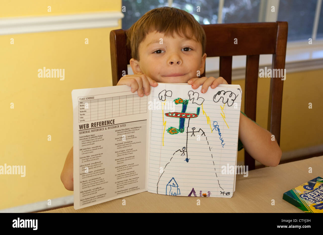 7 Jahre alten mexikanisch-amerikanischen jungen zeigt Zeichnung im Notebook während zu Hause während der Sommerferien Stockfoto