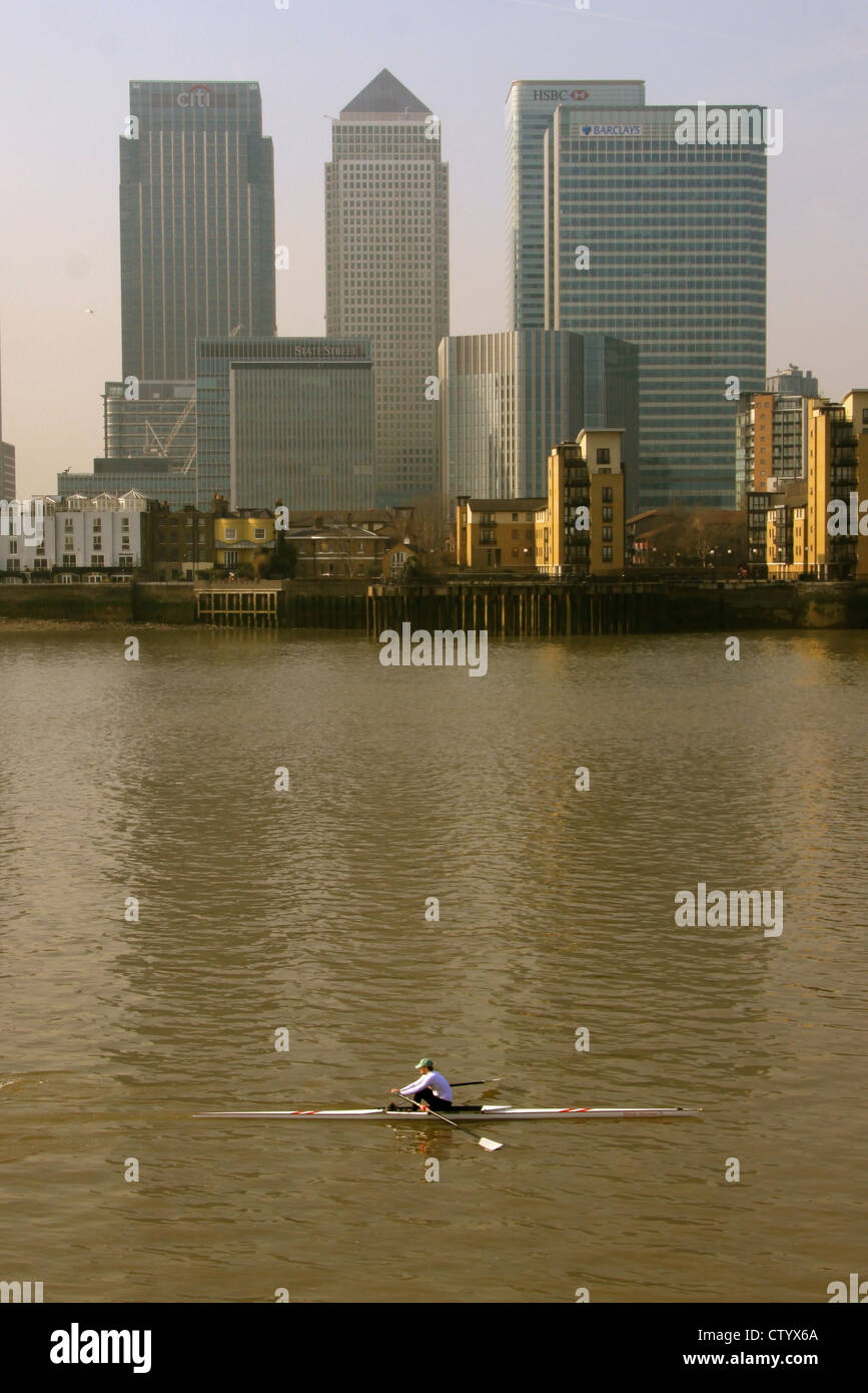 Einzelnen Schädel Ruderer vorbei Canary Wharf an der Themse, London. Stockfoto