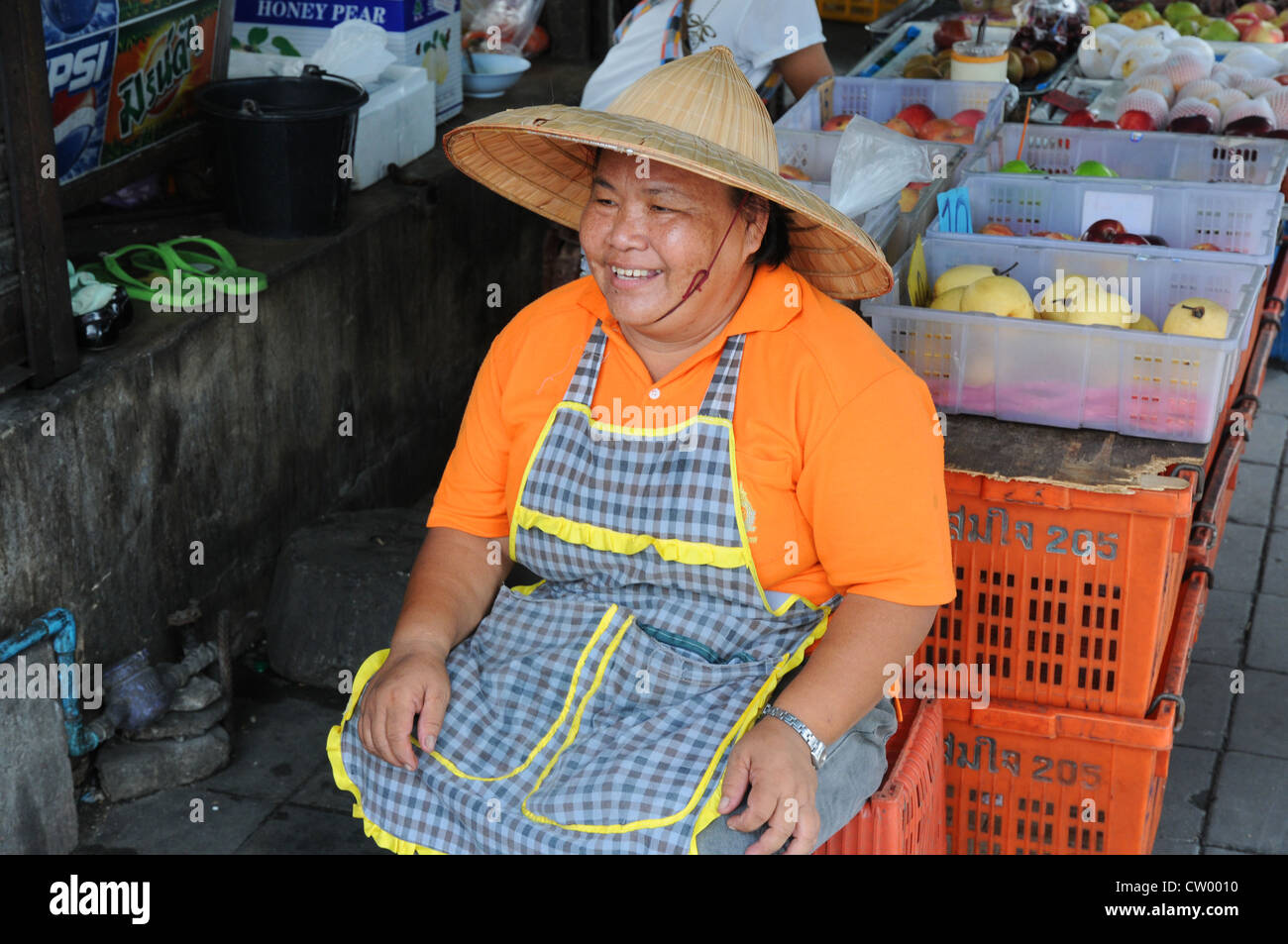 Lächelnde Frau sitzen an ihren überdachten Marktstand, Verkauf von Obst, Asoke Road und Sukhumvit Road, Soi 21, Bangkok Stockfoto
