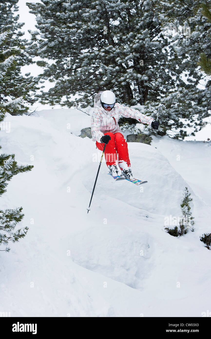 Springen auf verschneiten Hang Skifahrer Stockfoto