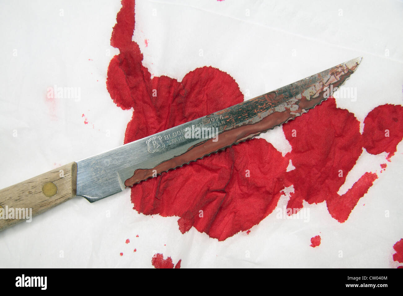 Eine simulierte scharfkantigen blutigen Sägemesser auf künstlichem Blut bedeckt weißes Tuch. Stockfoto