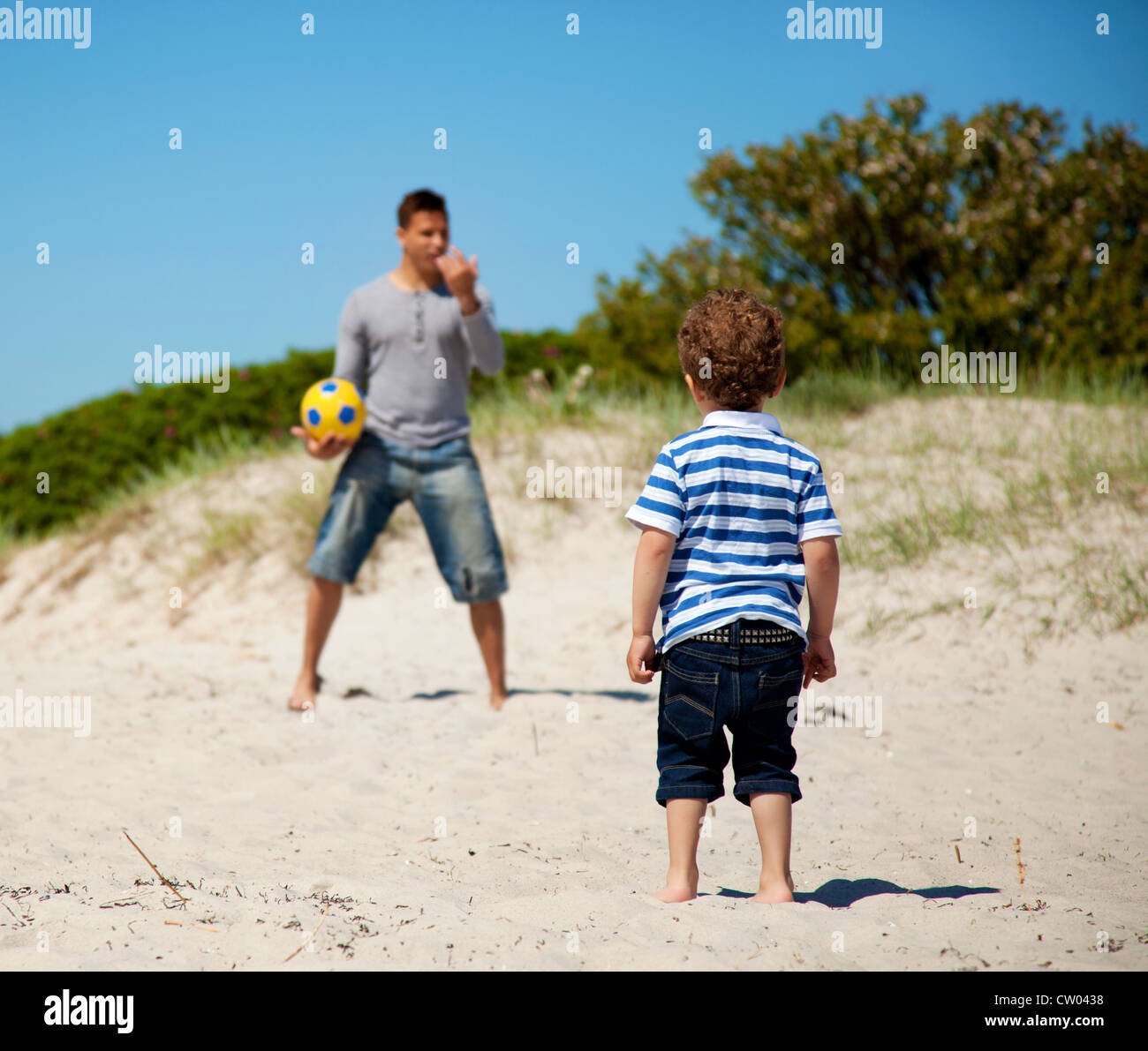 Kind auf seinen Vater, ihm beizubringen, wie man Fußball im Freien spielen Stockfoto