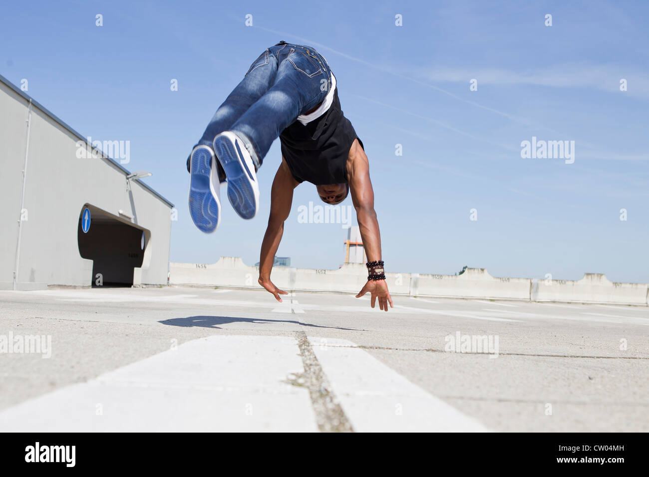 Mann springt auf Dach Stockfoto