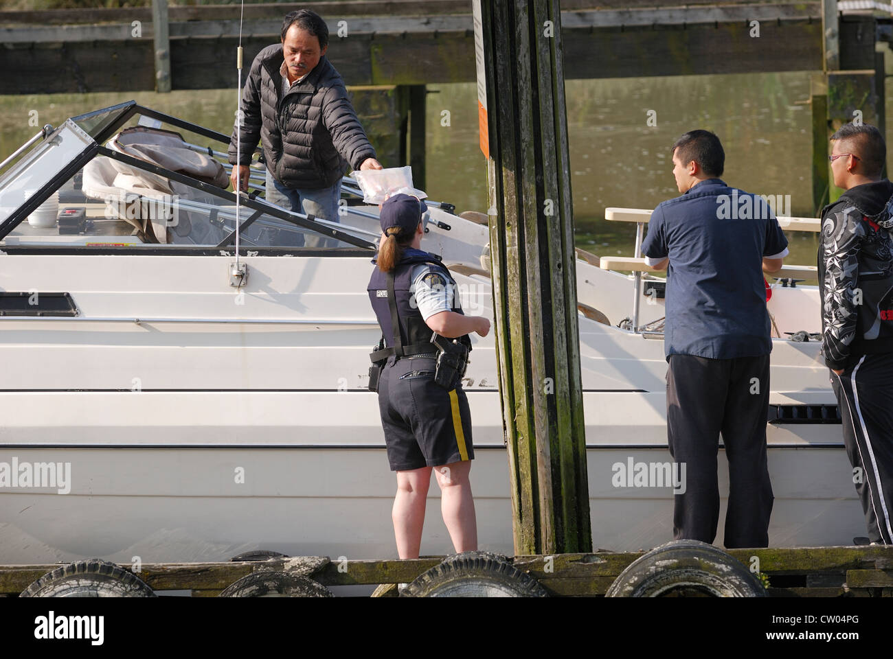 RCMP Offizier eine sicherheitstechnische Überprüfung auf Sportboote zu tun. Stockfoto