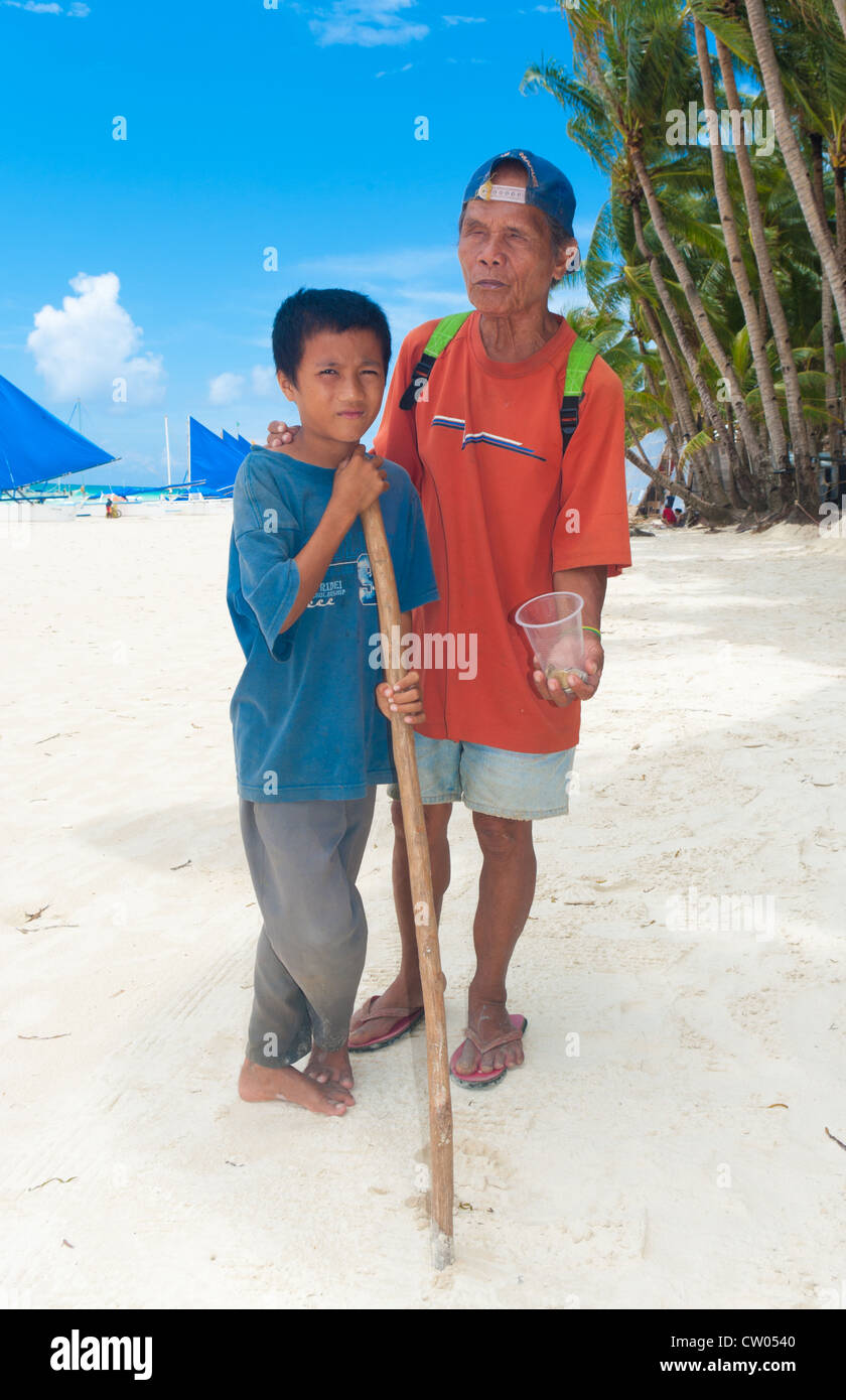 blinde Bettler mit seinem Sohn an einem tropischen Strand Stockfoto