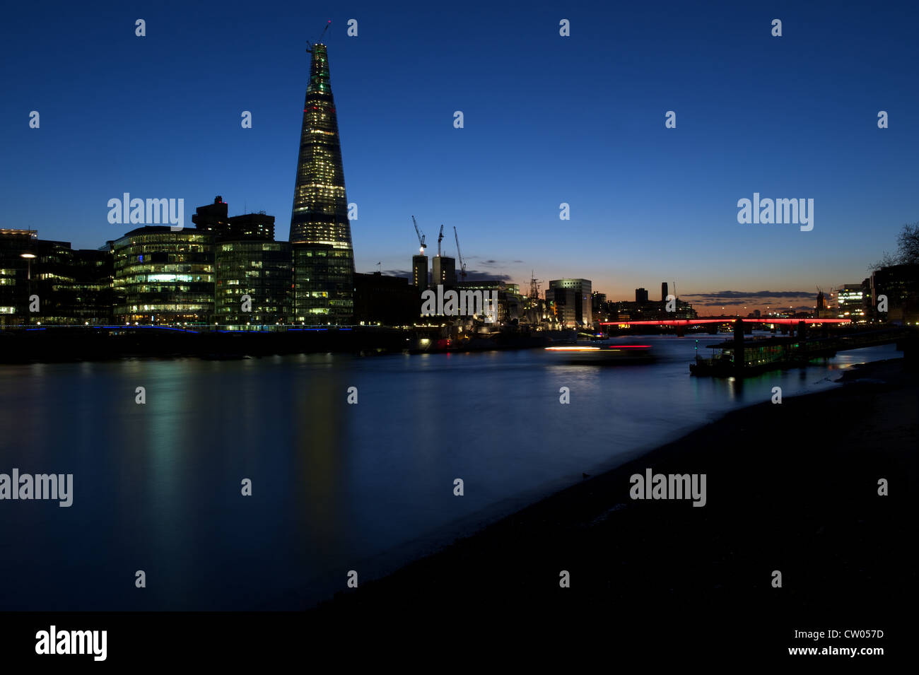 Banken der Londoner Themse in der Dämmerung: der Shard Gebäude, HMS Belfast und London Bridge beleuchtet, London, UK Stockfoto