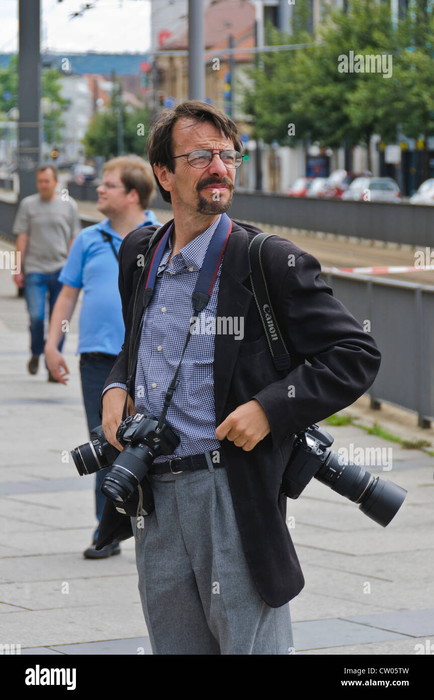 Professioneller Fotograf trägt drei CANON EOS DSLR-Kameras mit Zoom-objektiven um seinen Hals Stockfoto
