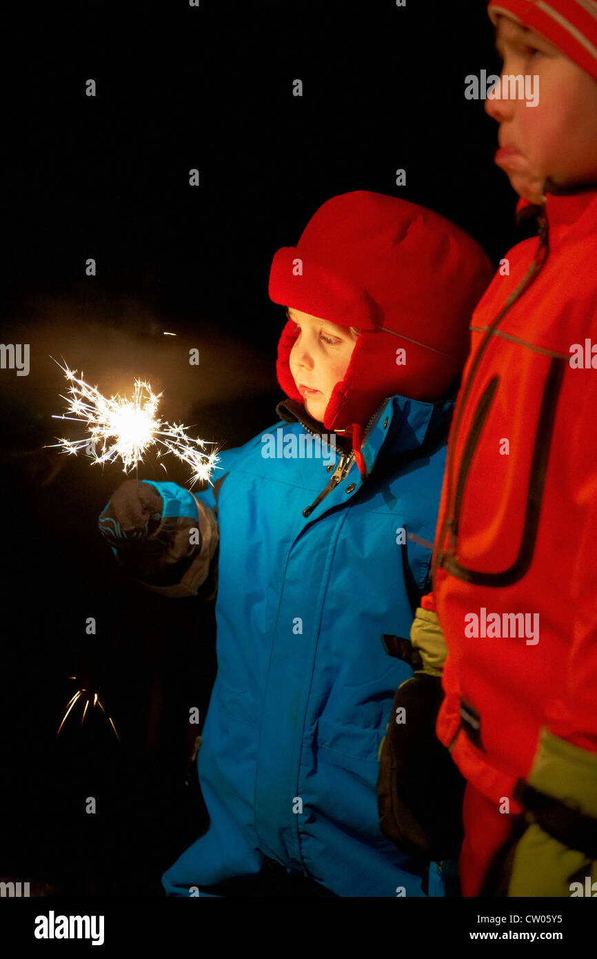 Jungen spielen mit Wunderkerze im freien Stockfoto