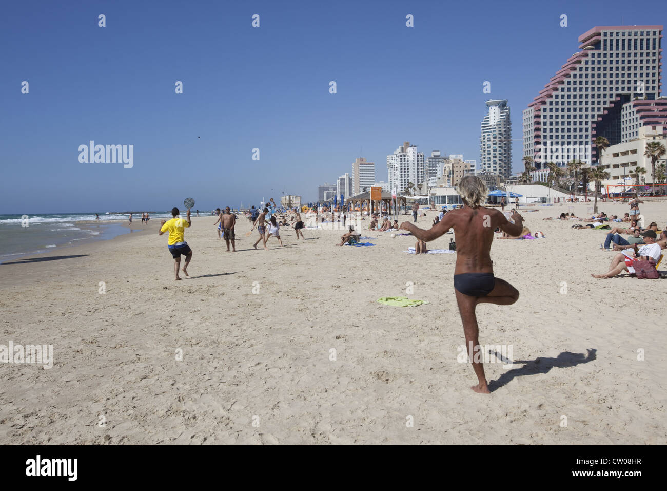 Eine Person in der Yoga-Körperposition Vriksasana oder Baum stellen am Strand in Tel Aviv, Israel. Stockfoto