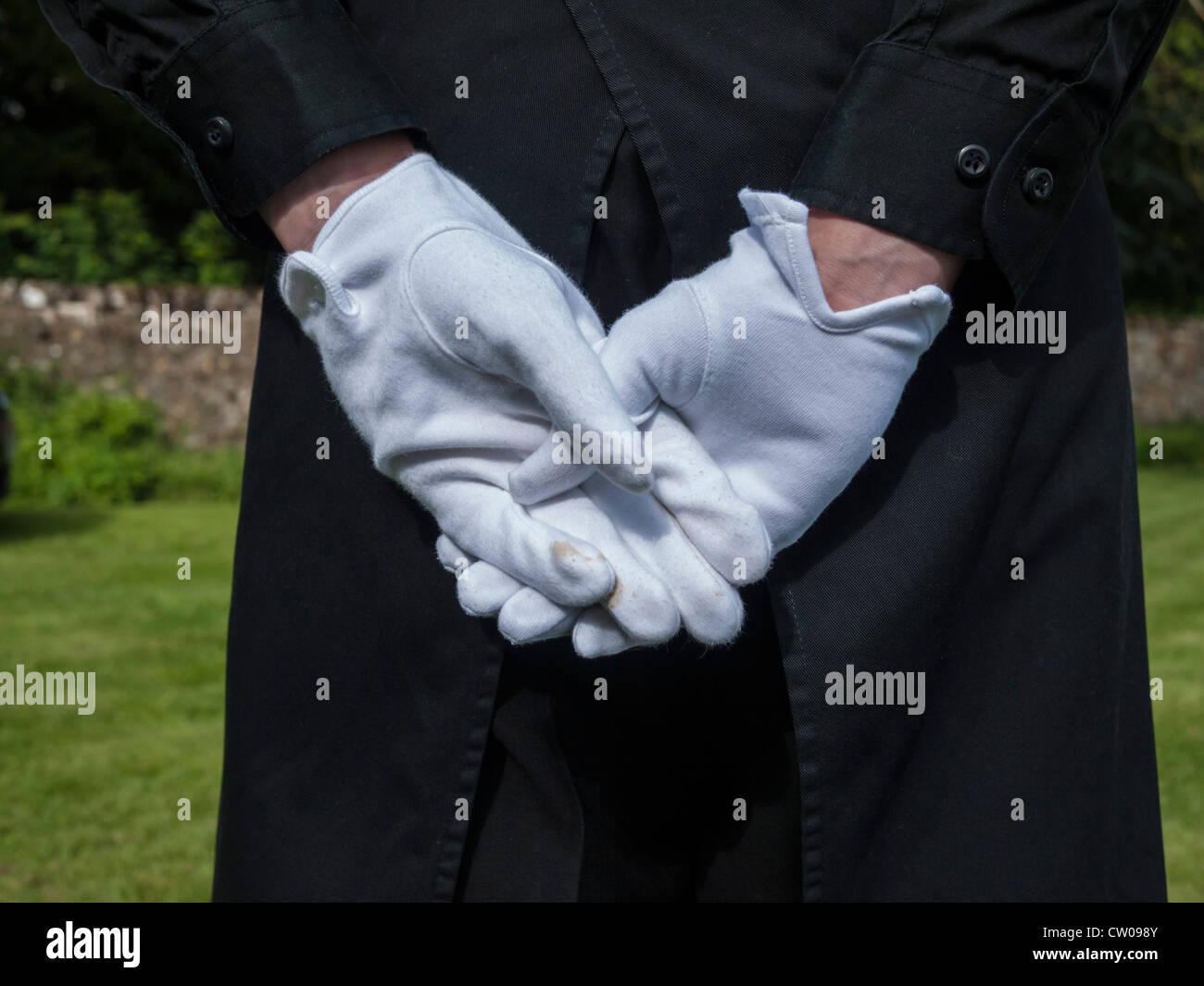 Weiß behandschuhten Hände eines catering Assistant hielt hinter wieder schließen. Stockfoto