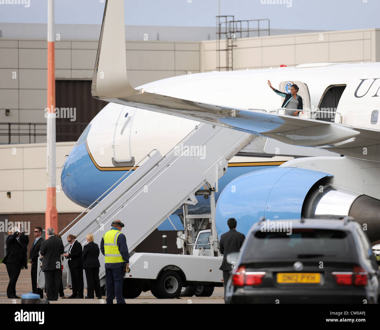 RAF MILDENHALL, England -- die erste Dame Michelle Obama winkt US-Militärfamilien bei RAF Mildenhall hier am 29. Juli 2012 zu. Familien, die RAF Mildenhall, RAF Lakenheath und dem 501. Kampfunterstützungs-Flügel zugeordnet waren, gehörten zu den Familien, mit denen die erste Dame vor ihrer Abreise traf. Obama hielt an der Basis als Teil der Initiative der Vereinten Kräfte. Während ihres Aufenthalts in Großbritannien traf die First Lady im Rahmen von Let’s Move mit rund 1,000 britischen und amerikanischen Kindern zusammen. Kampagne und war auch die US-Präsidentendelegation für die Eröffnungsfeier der Olympischen Spiele 2012. Stockfoto