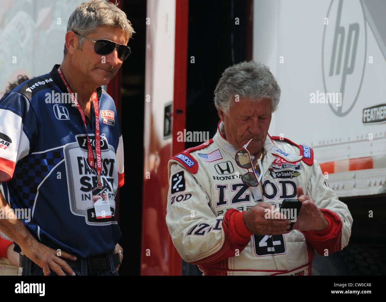 Mario Andretti bereitet sich darauf vor, Mitgliedern der Ohio National Guard, die am 2. August 2012 auf dem Mid-Ohio Sports Car Course ein Indy-Auto mit zwei Sitzen ausgewählt haben, zu geben. Die Nationalgarde sponsert Fahrer JR Hildebrand. Stockfoto