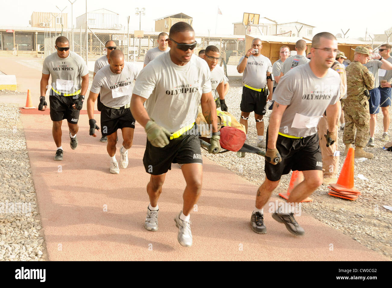Soldaten der US-Armee laufen während des Mülls tragen Teil der Kampfolympiade auf dem Kandahar Airfield, Afghanistan am 3. August 2012. Die Teams mussten auf der Promenade um die Strecke laufen und während des Laufs mit ihren Teamkollegen abschalten, während sie einen gewichteten Dummy trugen. Sieben Teams nahmen an den Olympischen Spielen Teil, darunter sechs anstrengende Events, darunter ein 5k-Lauf, Reifenflip, Liegestütze, Humvee-Push, Wurftrage und Tauziehen. Die Veranstaltung wurde vom Focus 5/6 Leadership Council on KAF gesponsert und die Einnahmen wurden zwischen dem rat und der Wounded Warrior Foundation aufgeteilt Stockfoto