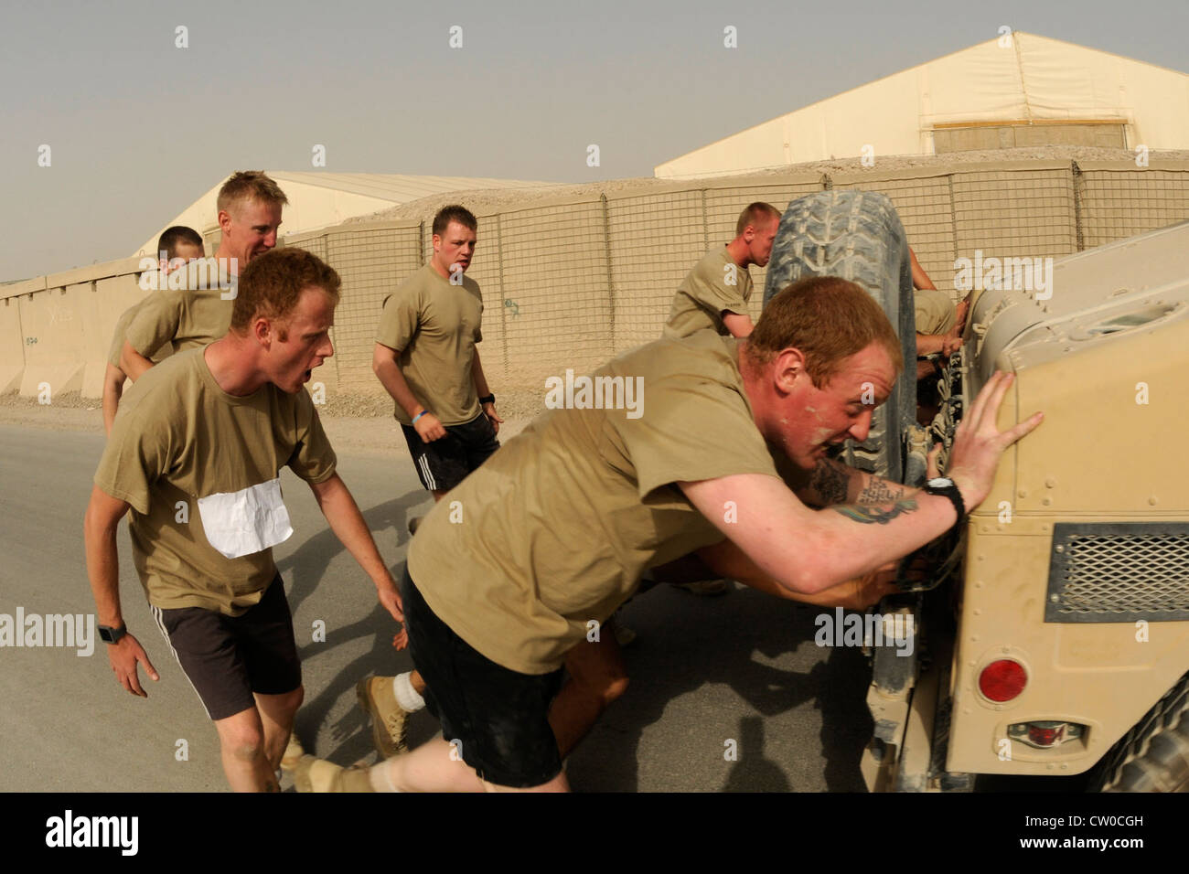 Soldaten mit den britischen armyâ €™s KSSG jubeln auf ihre Freunde, während sie schieben einen Humvee während der Olympischen Spiele statt 3. August 2012 in Kandahar Airfield, Afghanistan. Sieben Teams nahmen an den Olympischen Spielen Teil, darunter sechs anstrengende Events, darunter ein 5K-Lauf, Reifenflip, Liegestütze, Humvee-Push, Wurftrage und Tauziehen. Die Veranstaltung wurde vom Focus 5/6 Leadership Council auf dem Kandahar Airfield gesponsert und die Einnahmen wurden zwischen dem rat und der Wounded Warrior Foundation aufgeteilt. Stockfoto
