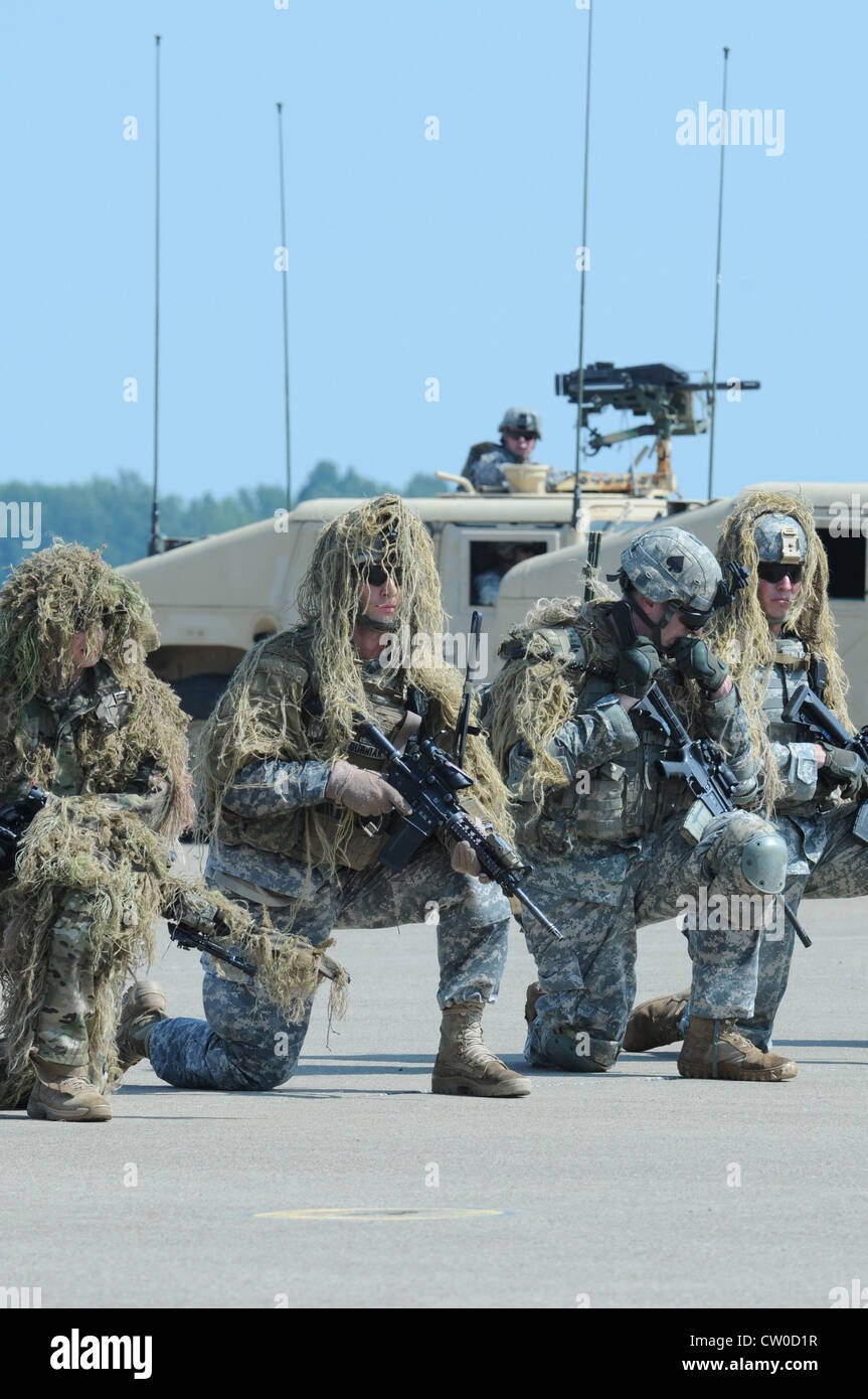 Soldaten in Ghilleanzügen knallen vor HMMWVs, während Hubschrauber am Dienstag während einer Generalprobe für die bevorstehende Flugshow auf dem Campbell Army Air Field fliegen. Die Luftangriffsdemonstration findet am Samstag im Rahmen der Fort Campbell Air Show statt, die um 10 Uhr beginnt Stockfoto