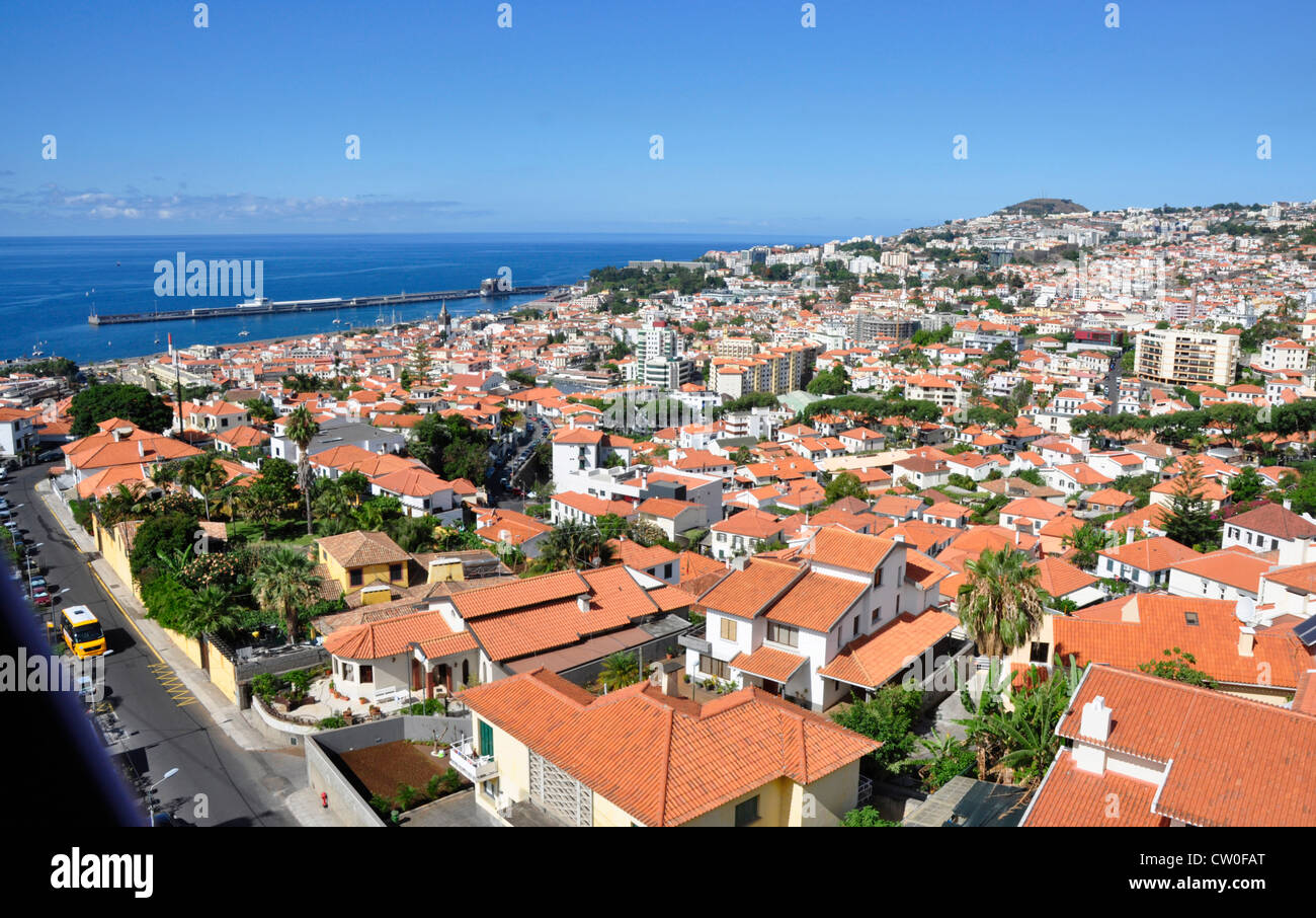 Portugal - Madeira - Funchal Stadt - Blick von der Seilbahn Monte über Dächer bis zum Meer - Sonne und blauer Himmel Stockfoto