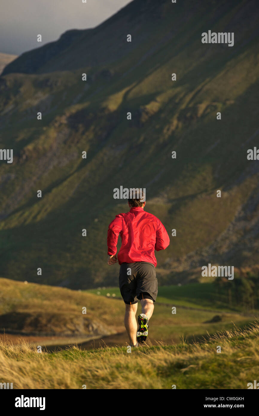 Mann läuft auf ländlichen Bergstraße Stockfoto