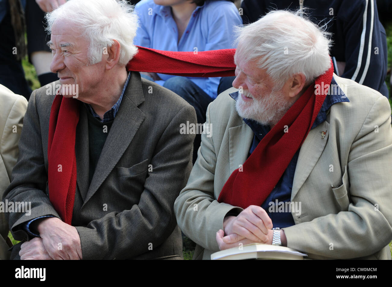 Die verblendeten Seamus Heaney & Michael Longley teilen einen roten Schal beim Anhören einer Lesung an der Hügel von Tara, Irland Stockfoto