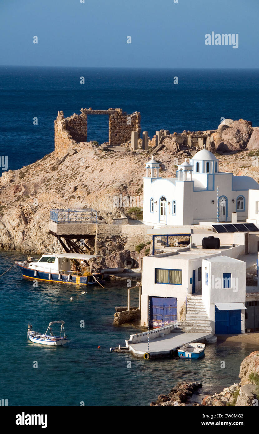 Fischer-Häuser in Felsen am Mittelmeer Meer Firopotamos griechischen Insel Milos Kykladen Griechenland mit griechischen Kirche Stockfoto