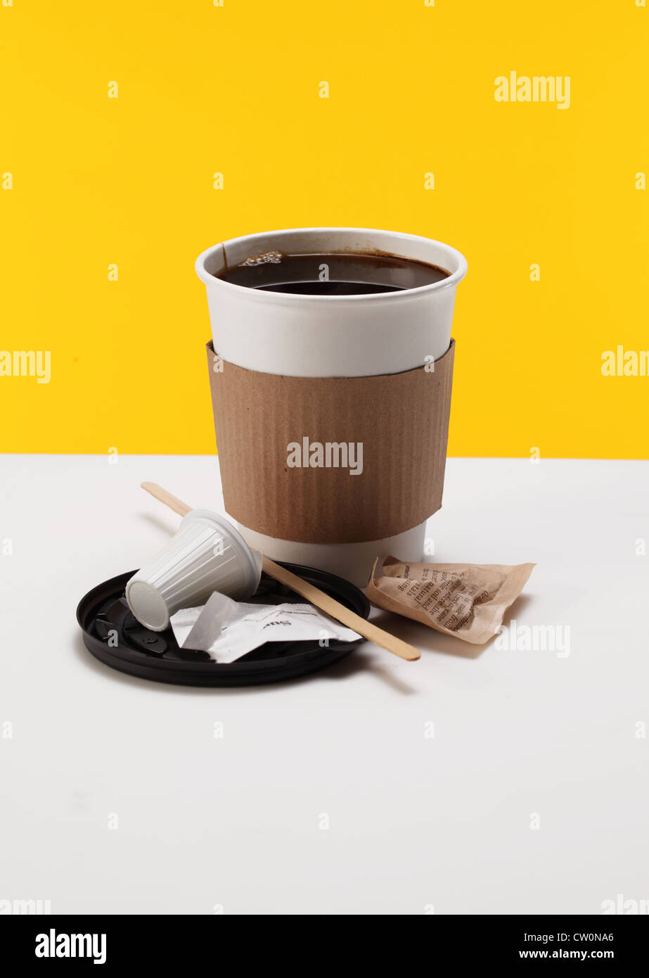 Eine Kaffeetasse mit Löffel, rühren Stick, Serviette, Deckel, Milchkännchen Paket und Zucker. Stockfoto