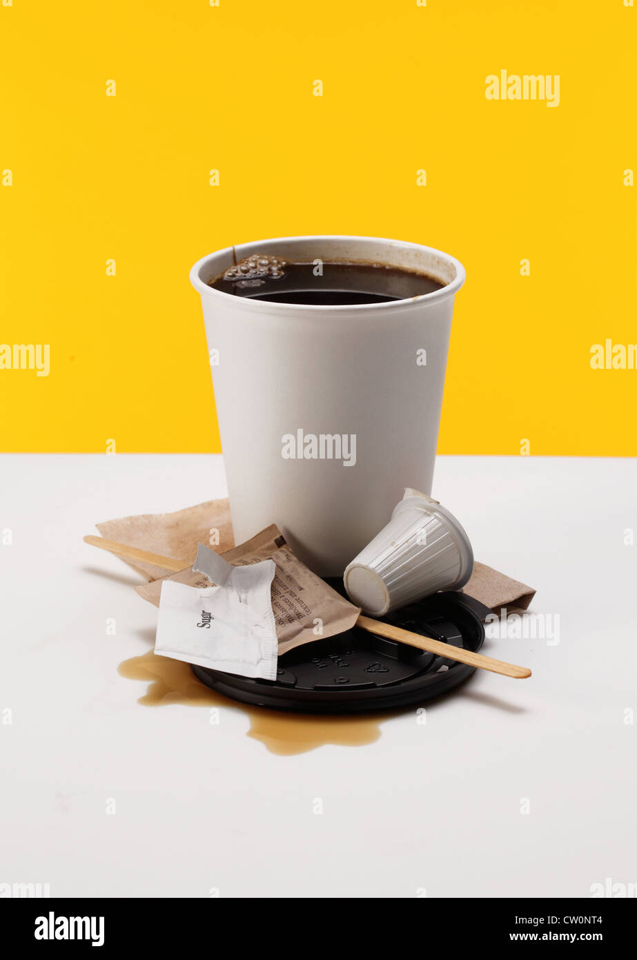 Eine Kaffeetasse mit Löffel, rühren Stick, Serviette, Deckel, Milchkännchen Paket und Zucker. Stockfoto