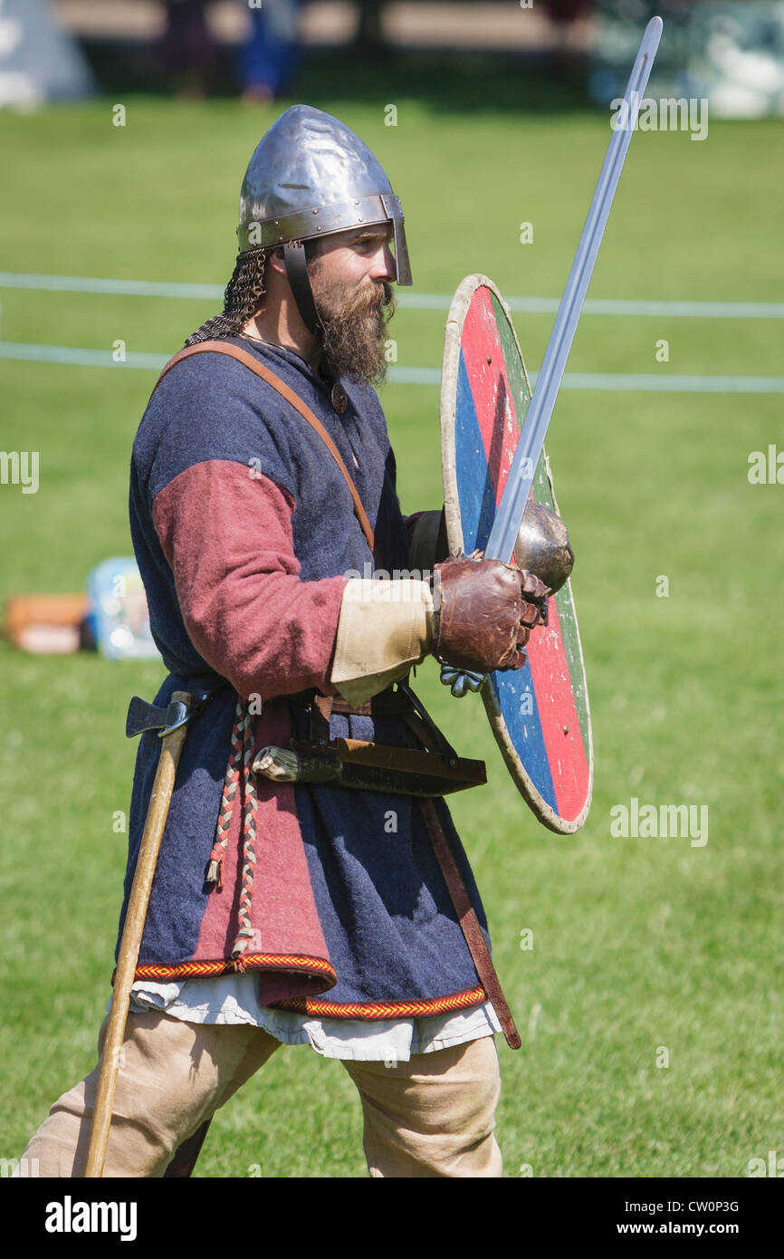 Mann in frühen mittelalterlichen Kostüm steht mit Schwert und Schild während Anglo-Saxon und Viking Reenactment. St Albans, UK. Mai 2012 Stockfoto
