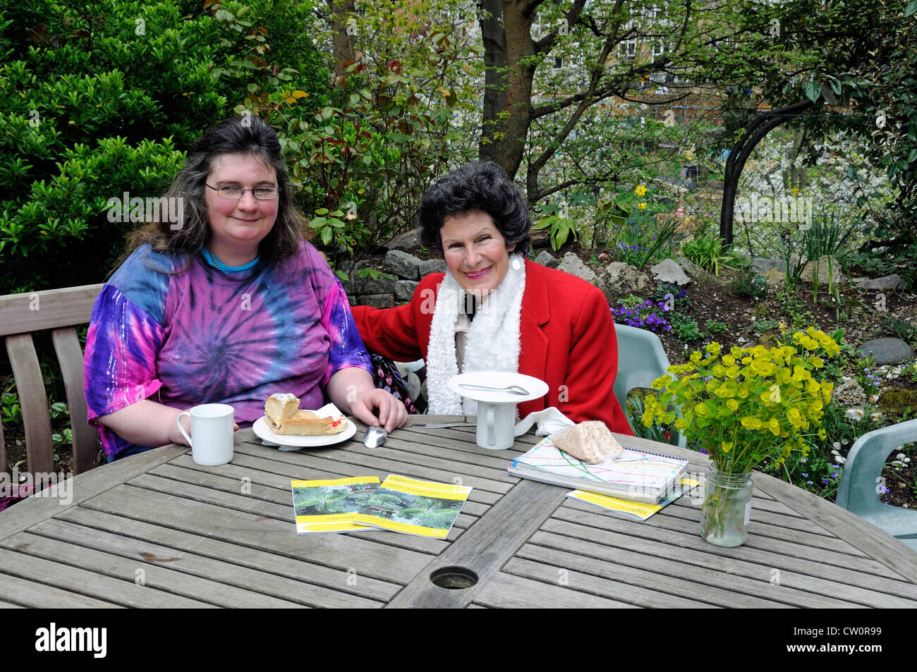 Bunt gekleidete Damen mit Tee und Kuchen im Garten Olden Tag National Garden Scheme NGS Highbury ILondon UK öffnen Stockfoto