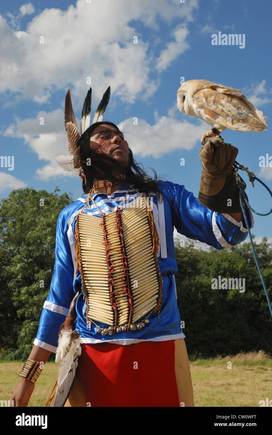 Ein Mann posiert im traditionellen Kleid Lakota (Sioux) mit einer Schleiereule. Stockfoto