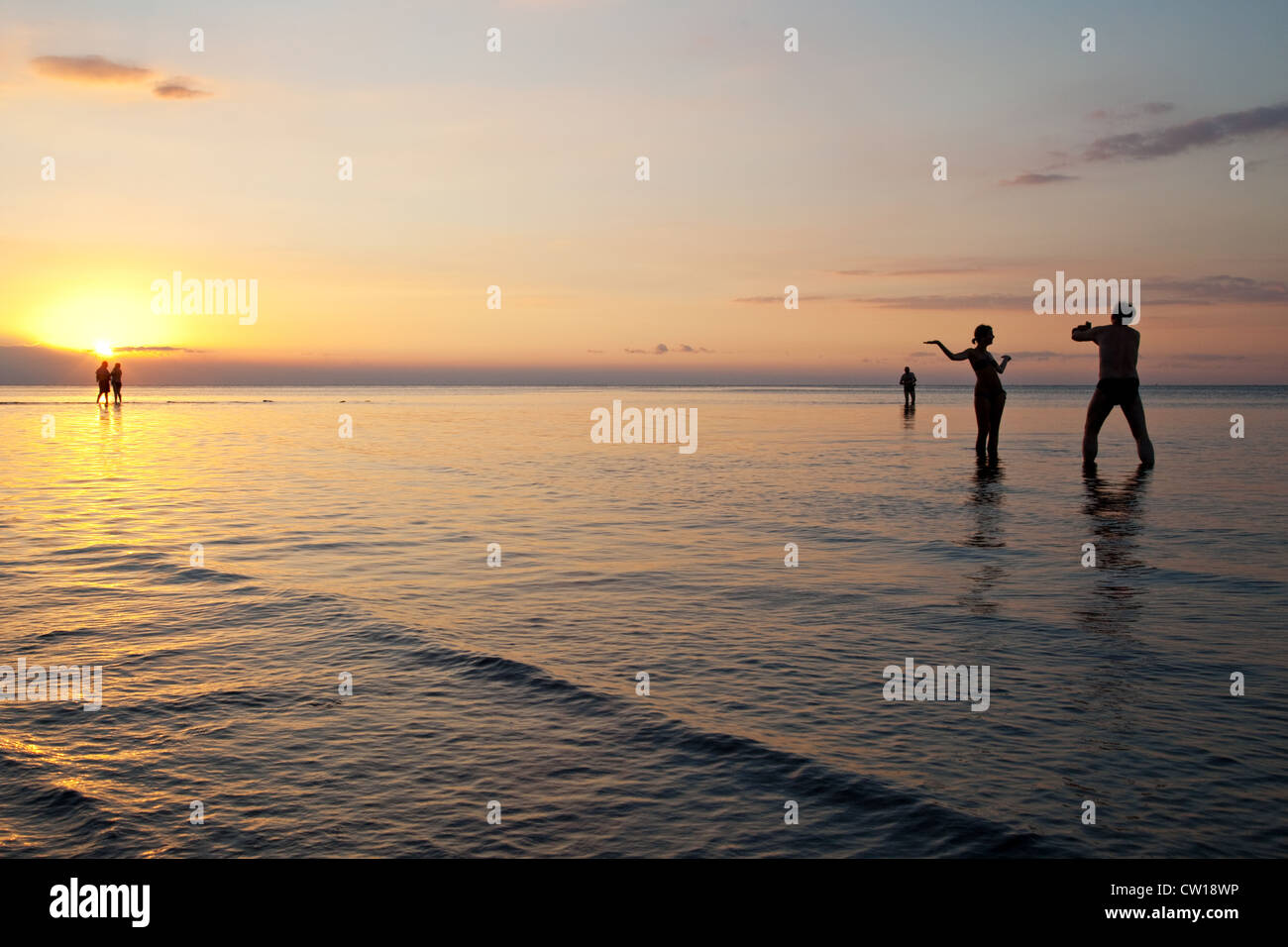 Menschen im Meer am Strand von Lovina im Sonnenuntergang, Lovina, Bali, Indonesien. Stockfoto