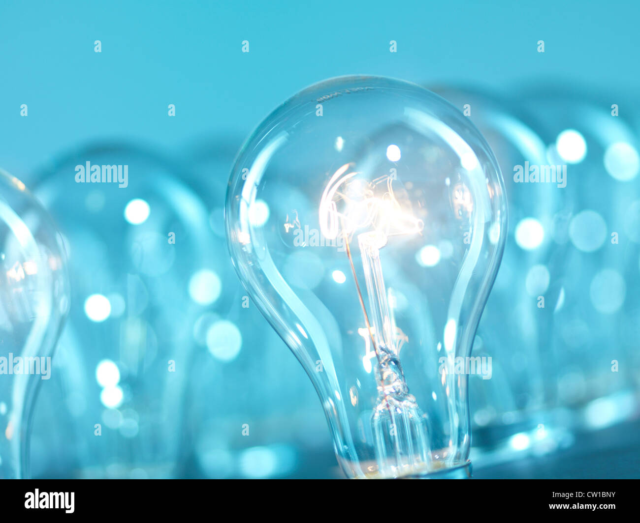 Eine beleuchtet glühende Wolfram Glühbirnen aus vielen. Abstrakter blauer Hintergrund. Stockfoto