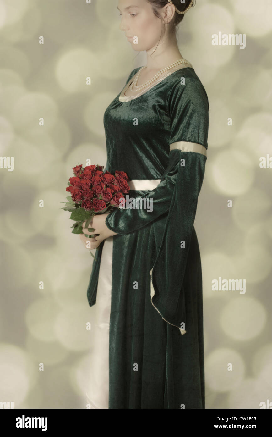 eine Frau in einem viktorianischen Kleid mit einem Strauß Rosen Stockfoto