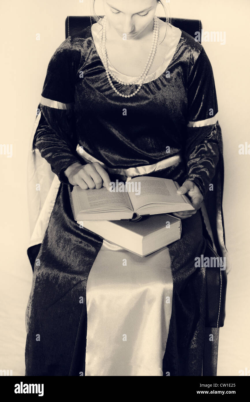 eine Frau in einem viktorianischen Kleid, ein Buch zu lesen Stockfoto