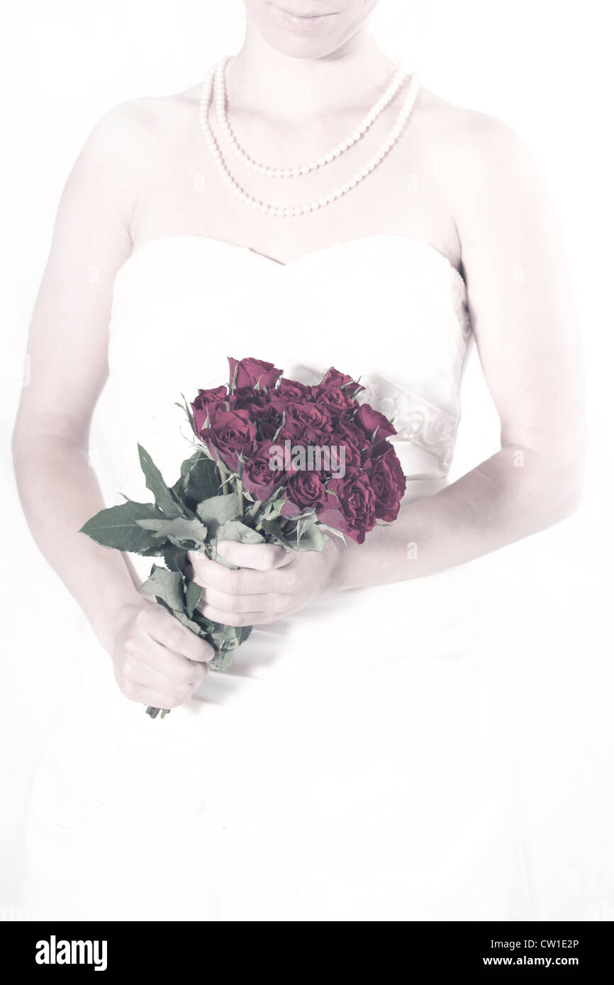 eine Frau in einem weißen Kleid mit einem Strauß Rosen Stockfoto