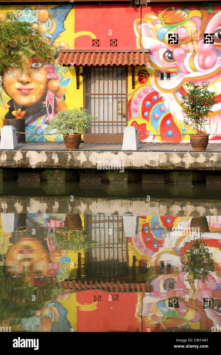 Bunte Wandmalereien am Flussufer am Fluss Melaka in Melaka. Stockfoto