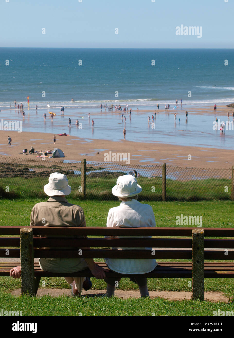 Altes Ehepaar saßen auf der Parkbank mit Blick auf das Meer, Bude, Cornwall, UK Stockfoto