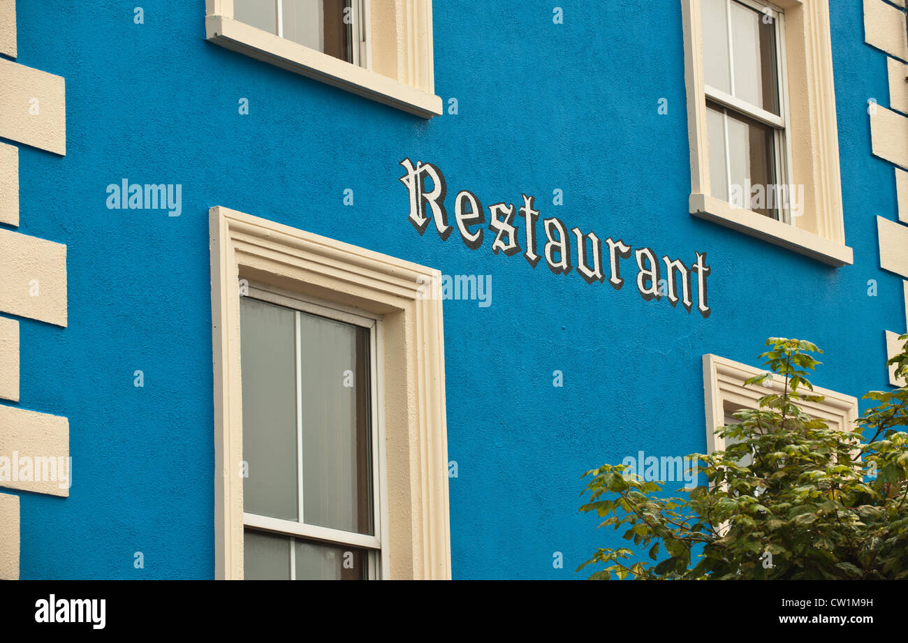 Ein Restaurant-Zeichen, das auf der Seite von diesem blauen Gebäude in Dungarvan, Irland gemalt worden ist. Stockfoto