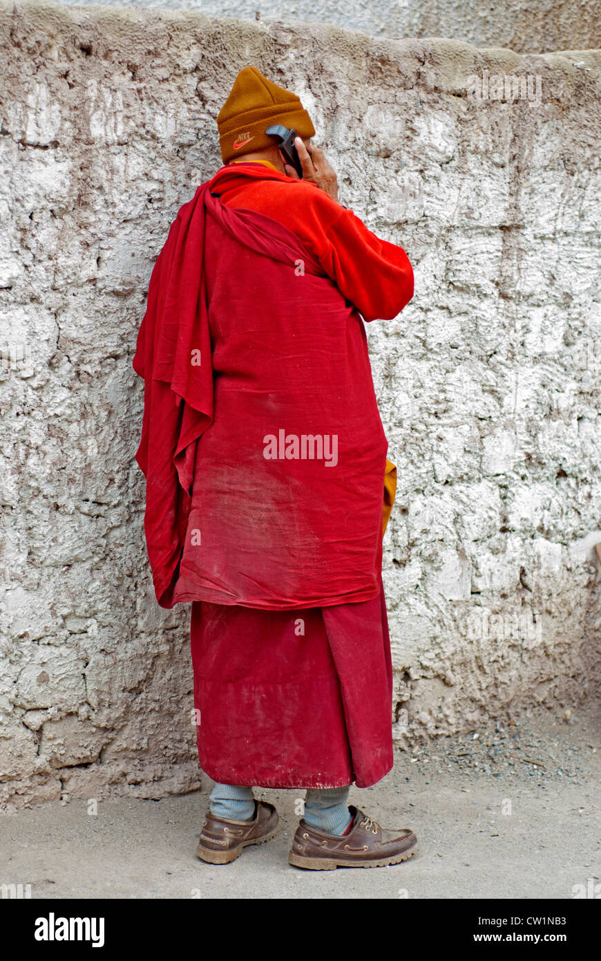 Ein Mönch, in den traditionellen roten Roben tragen ein Vlies Nike Hut auf  seinem Handy im Hemis Kloster, Ladakh, Indien sprechen Stockfotografie -  Alamy