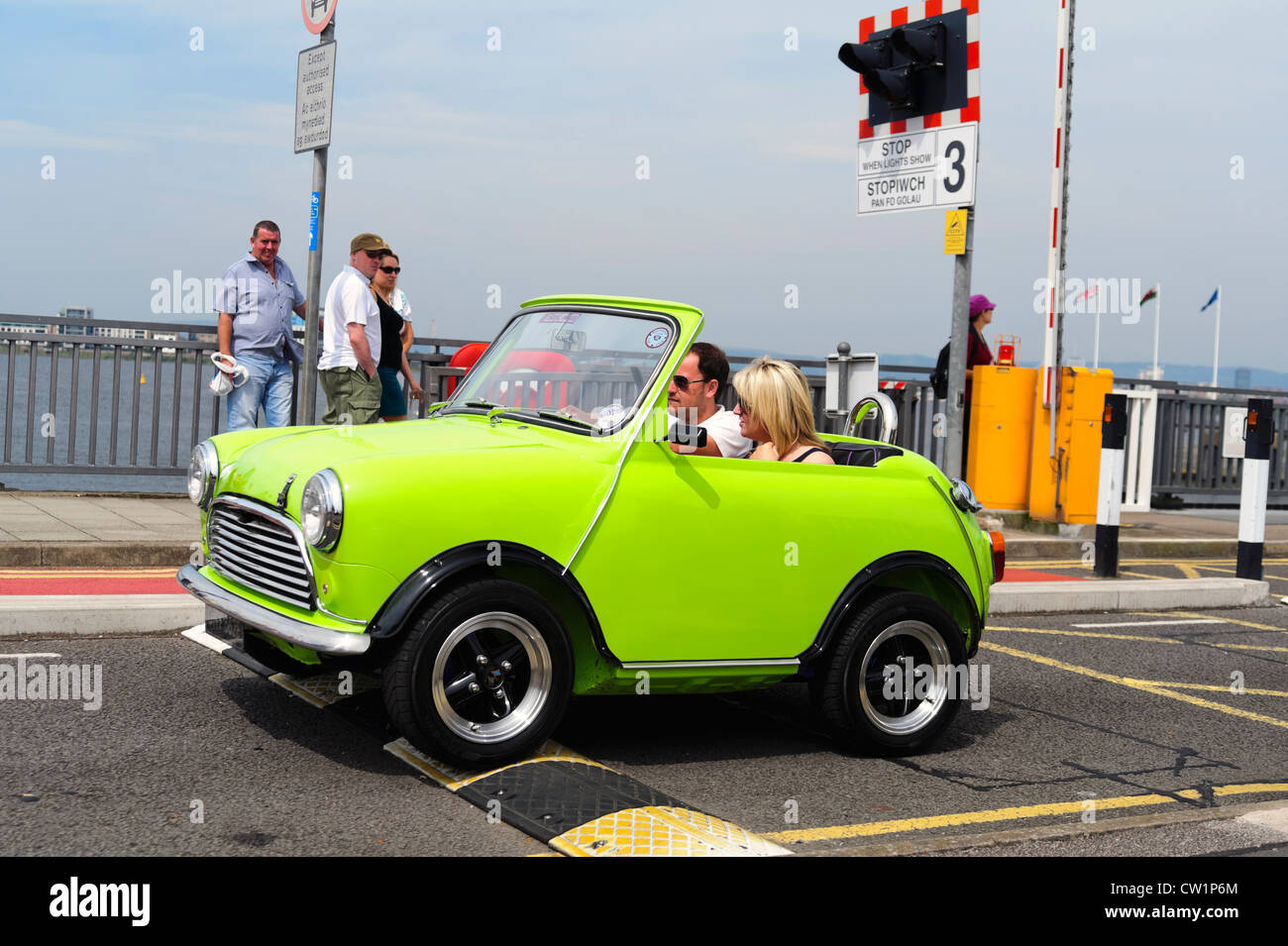 Klassische Mini Auto überfahren ein schlafender Polizist Speed Bump in Cardiff Bay Barrage, South Wales, Großbritannien. Stockfoto