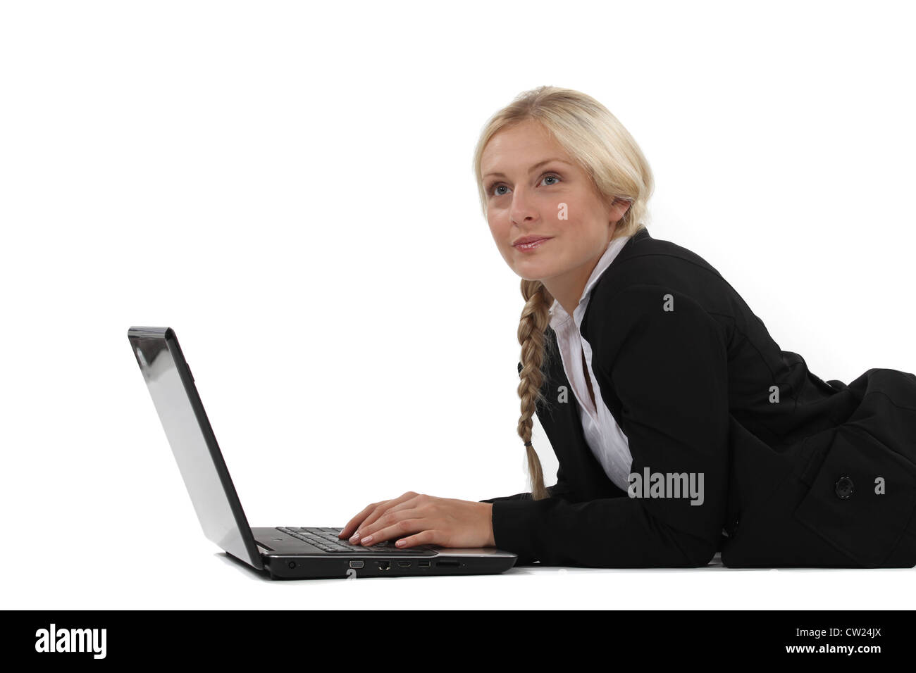 Verträumte Frau auf ihrem Laptop tippen Stockfoto