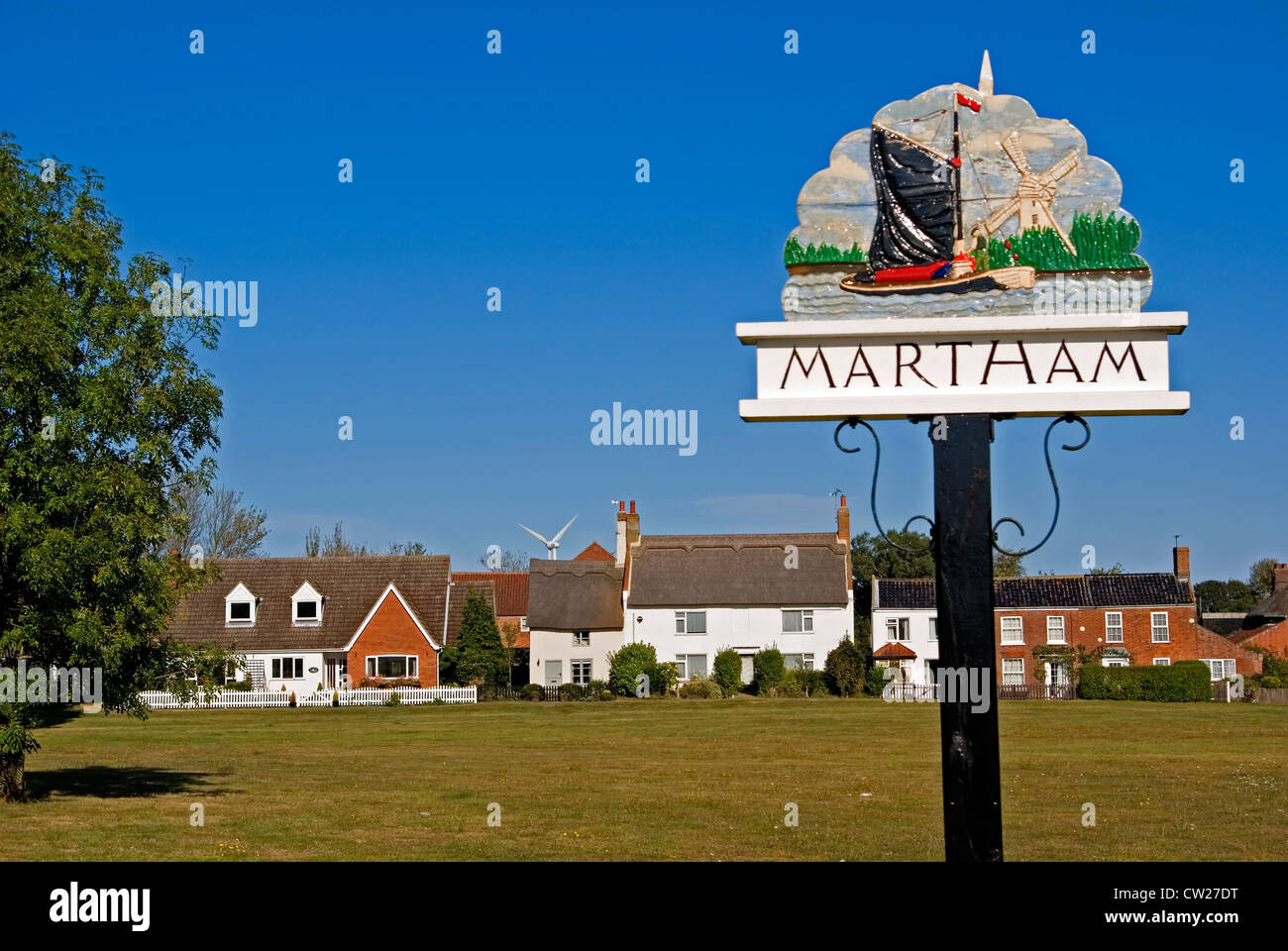 Der Dorfplatz in Martham in Norfolk, mit seinen strohgedeckten Cottages und Ortsschild. Stockfoto