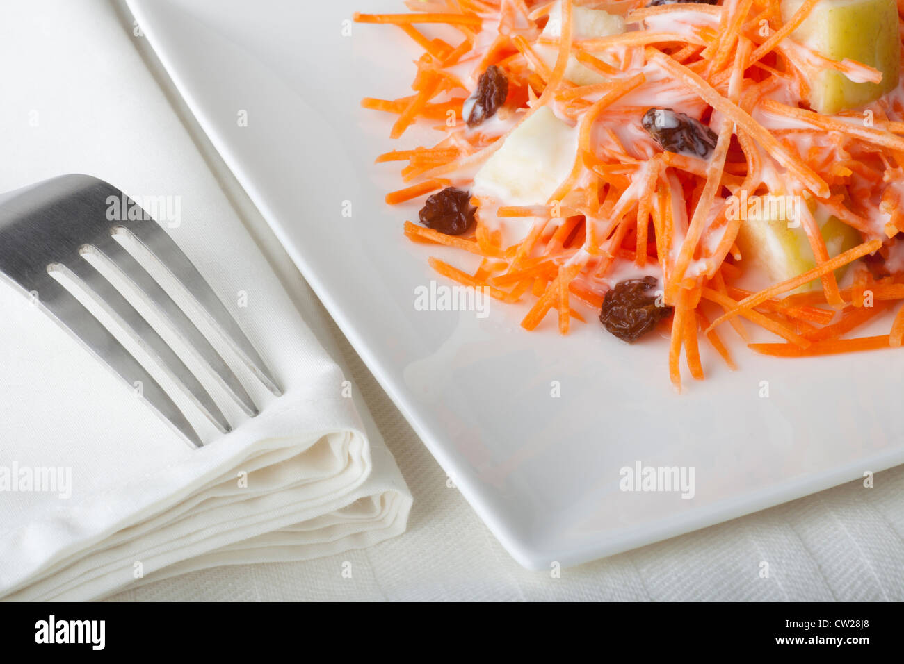 Frischen Karotten-Salat mit geriebenen Möhren, Rosinen, Äpfeln und einer leichten Curry Joghurtdressing. Stockfoto