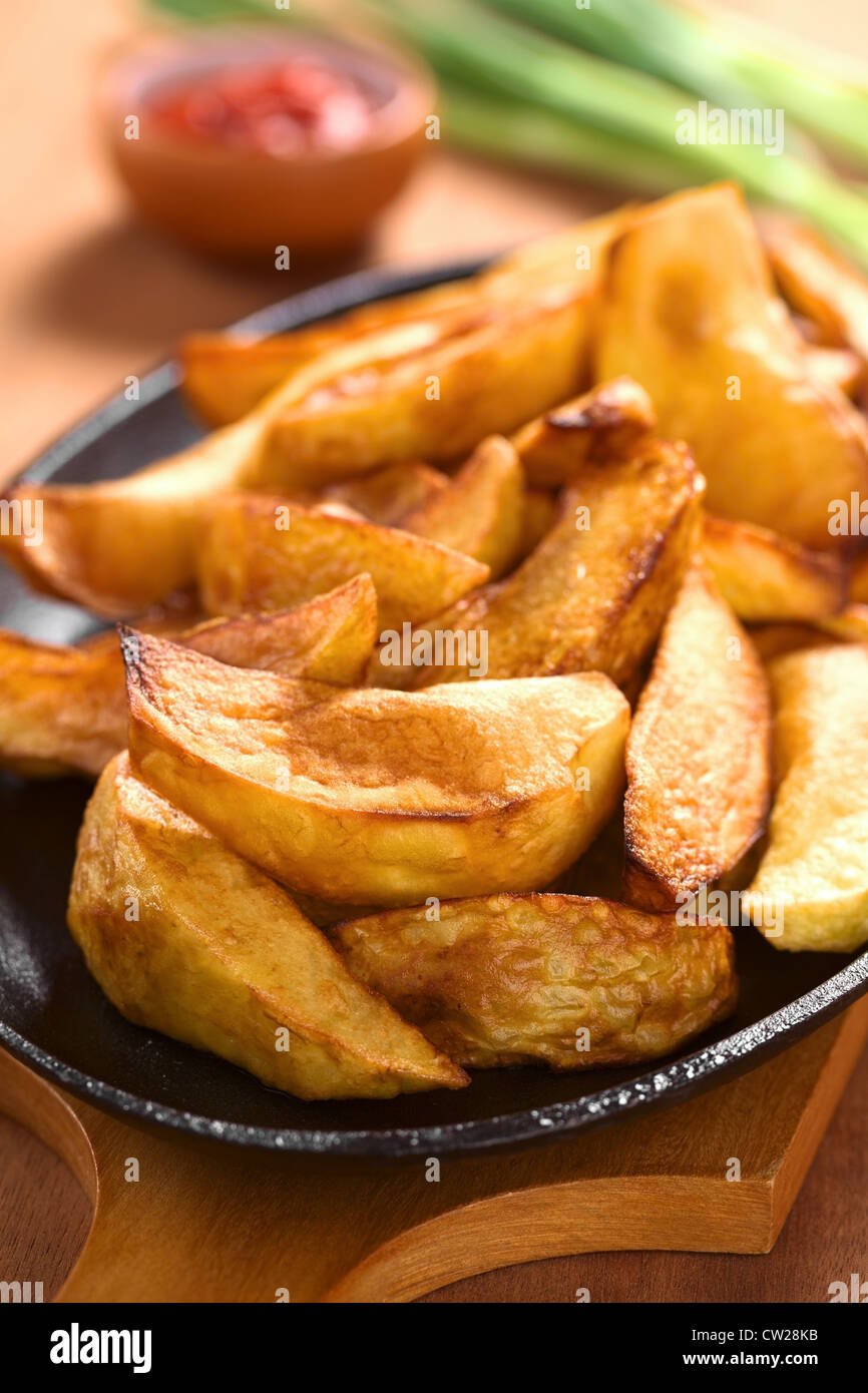 Frische hausgemachte Pommes frites Keile auf Metallplatte mit Ketchup und Schalotte in den Rücken Stockfoto
