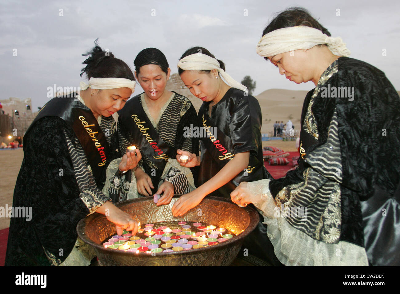 Dubai, asiatische Frauen, Kerzen anzuzünden Stockfoto