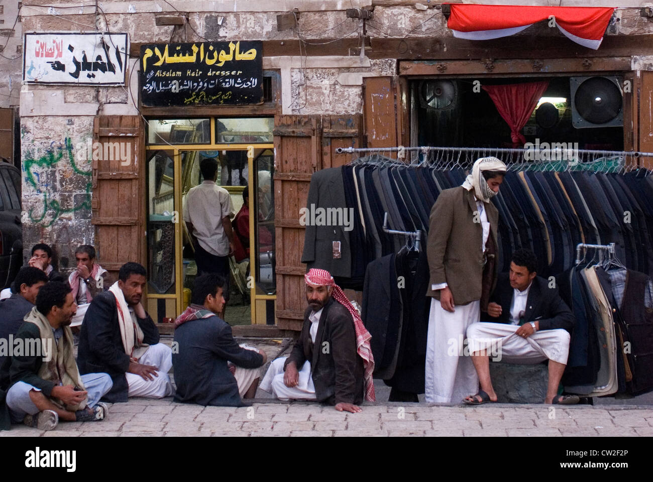 Männer vor einem Bekleidungsgeschäft in der Altstadt von Sana'a, einem UNESCO-Weltkulturerbe, Jemen, Westasien, Arabische Halbinsel. Stockfoto