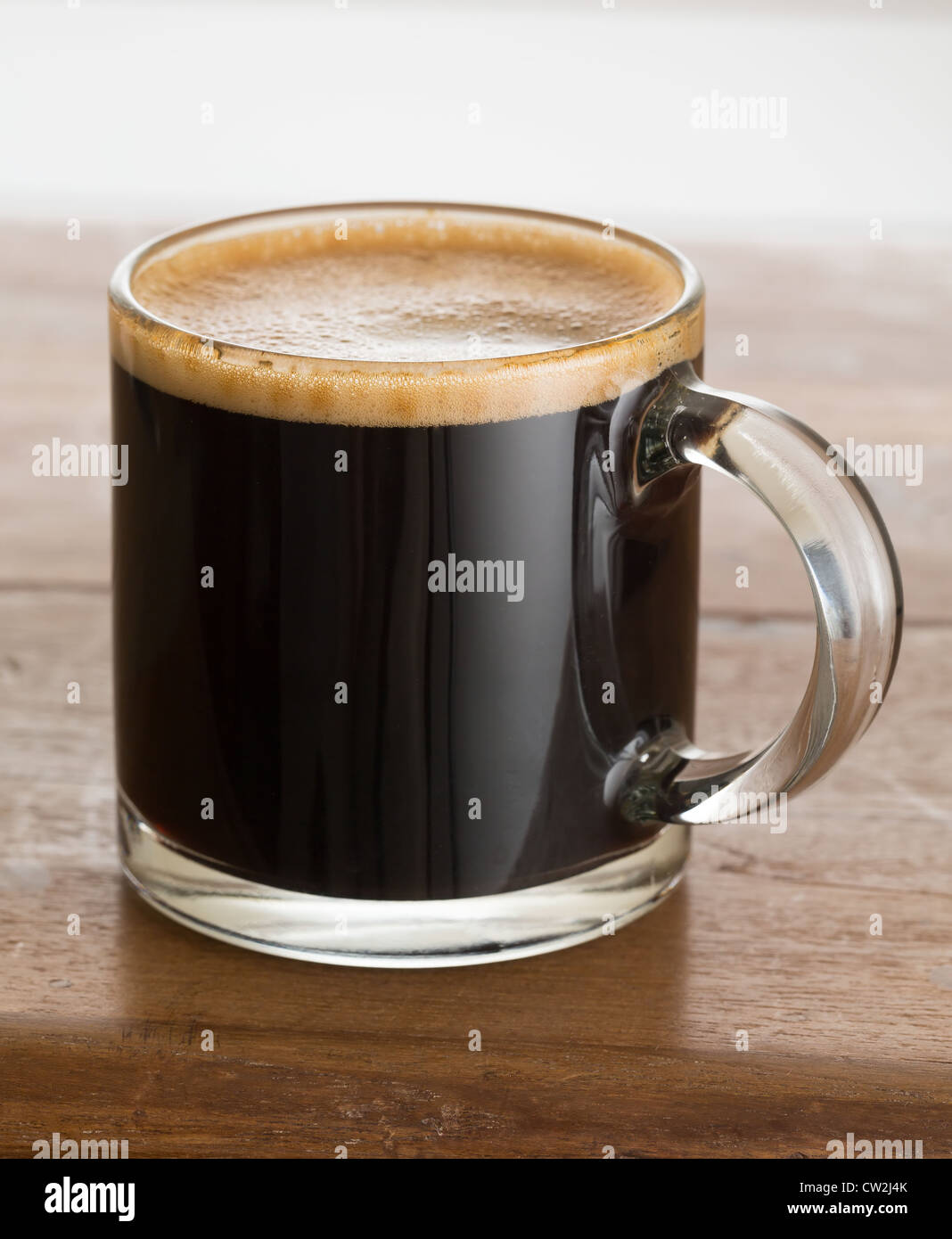 Schwarzer Espresso Kaffee in kleinen Glasschale auf Holztisch Stockfoto