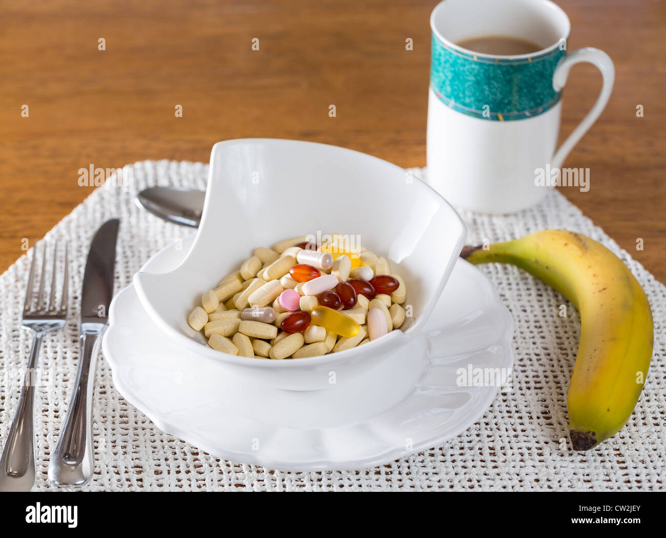 Vitamine in der Schale mit Tabletten zum Frühstück in der Küche Stockfoto