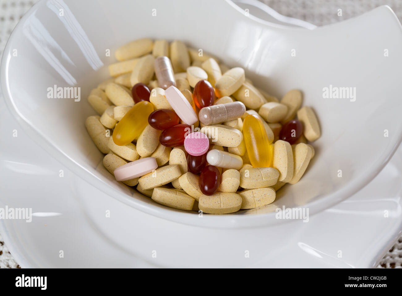 Vitamine in der Schale mit Tabletten zum Frühstück in der Küche Stockfoto