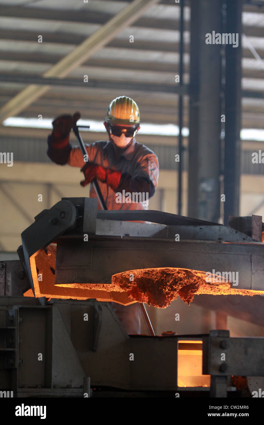 Ein Arbeiter Eisen Probenentnahme mit einer Lanze auf Gießerei Stockfoto